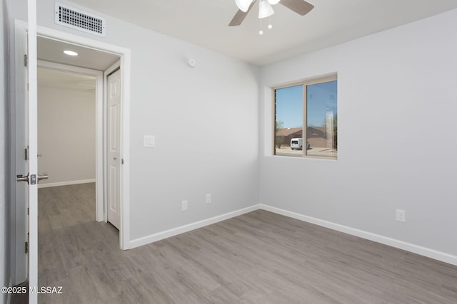 empty room with visible vents, baseboards, ceiling fan, and wood finished floors