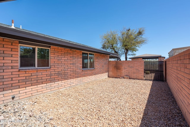 view of yard with a fenced backyard and a gate