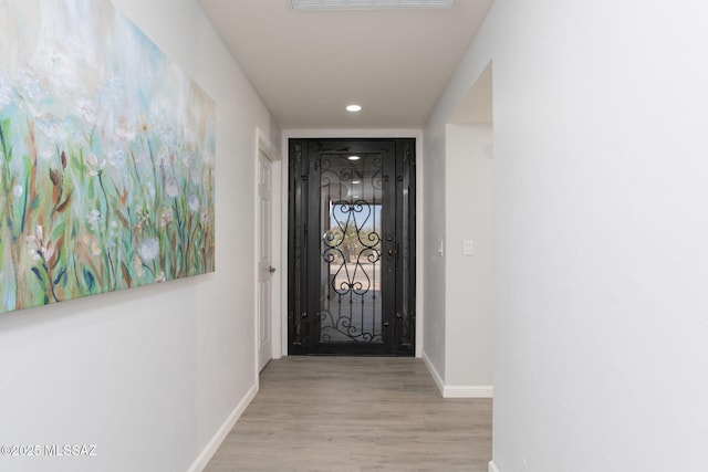 hallway with recessed lighting, baseboards, and wood finished floors