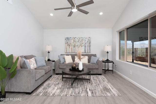 living room featuring baseboards, a ceiling fan, wood finished floors, and lofted ceiling