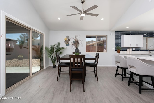 dining area featuring ceiling fan, light wood finished floors, and lofted ceiling