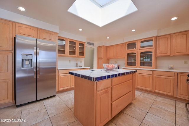 1402 N Camino Miraflores, Tucson, AZ 85745 - kitchen with stainless steel fridge, tile countertops, light brown cabinets, light tile patterned flooring, and recessed lighting