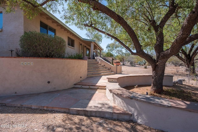 1402 N Camino Miraflores, Tucson, AZ 85745 - view of front of property featuring stucco siding, stairway, and a patio