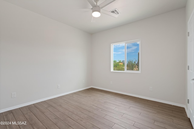 unfurnished room featuring visible vents, ceiling fan, wood finished floors, and baseboards