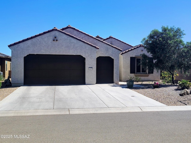 1417 E Claystone Dr, Green Valley, AZ 85614 - mediterranean / spanish home with an attached garage, stucco siding, concrete driveway, and a tile roof