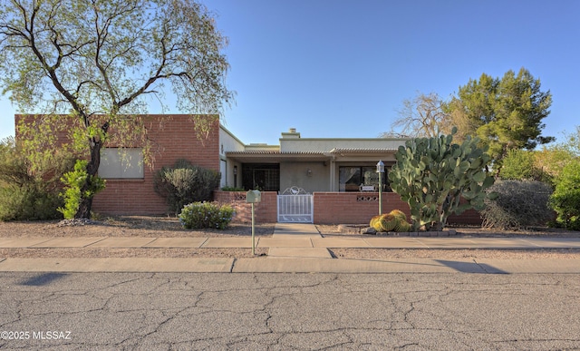 401 E Placita Del Venado, Green Valley, AZ 85614 - view of front of home featuring a fenced front yard, a gate, brick siding, and a chimney