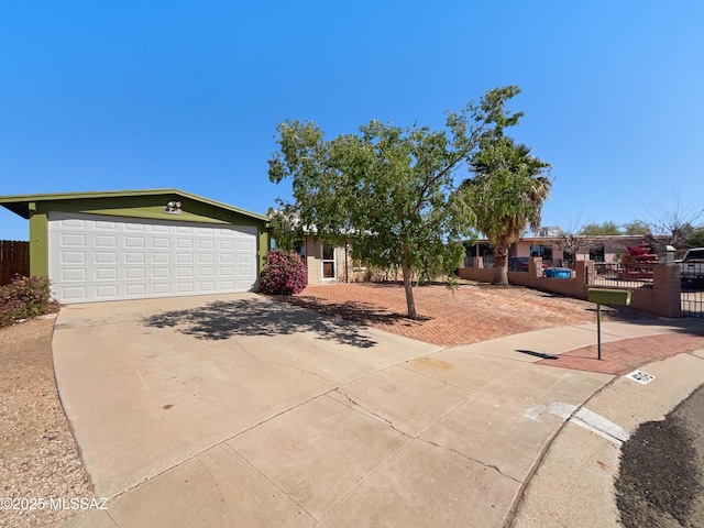 single story home with concrete driveway, a garage, and fence