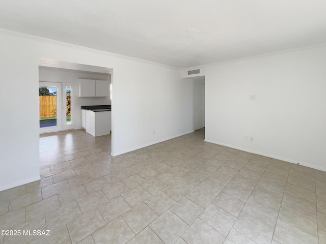 unfurnished room with crown molding, light tile patterned floors, baseboards, and visible vents