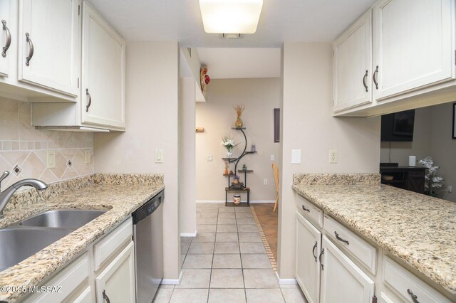 kitchen with white cabinets, a textured wall, and light stone countertops