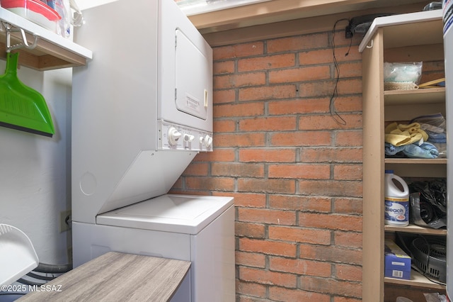 laundry area with stacked washer and dryer and laundry area
