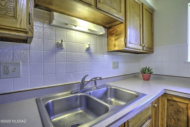3061 W Avenida Cresta, Tucson, AZ 85745 - kitchen featuring a sink, brown cabinetry, tasteful backsplash, and light countertops