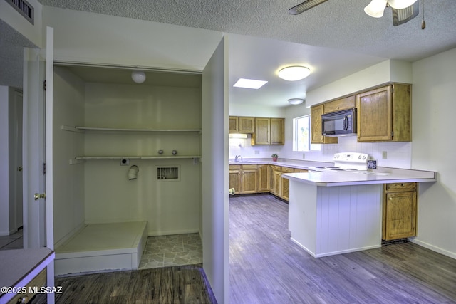 3061 W Avenida Cresta, Tucson, AZ 85745 - kitchen featuring black microwave, white electric range oven, dark wood-style floors, brown cabinetry, and a peninsula