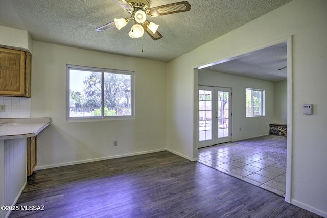 3061 W Avenida Cresta, Tucson, AZ 85745 - unfurnished dining area featuring a textured ceiling, french doors, dark wood finished floors, ceiling fan, and baseboards