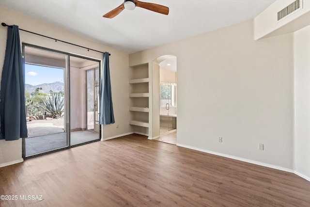 11460 N Palmetto Dunes Ave, Tucson, AZ 85737 - spare room featuring arched walkways, wood finished floors, visible vents, and ceiling fan