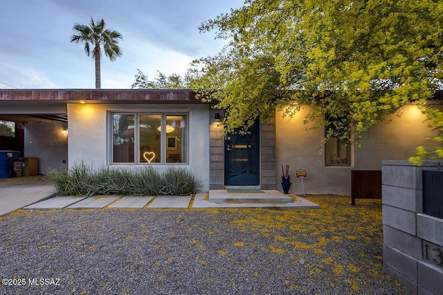 view of exterior entry featuring stucco siding