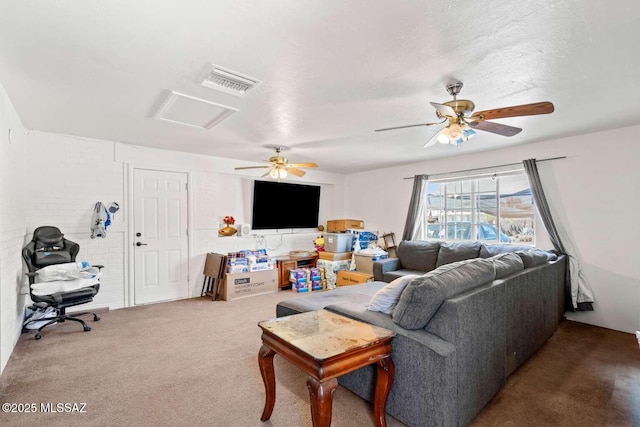 carpeted living area featuring visible vents, a ceiling fan, and attic access