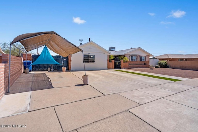 view of front of house featuring fence and concrete driveway