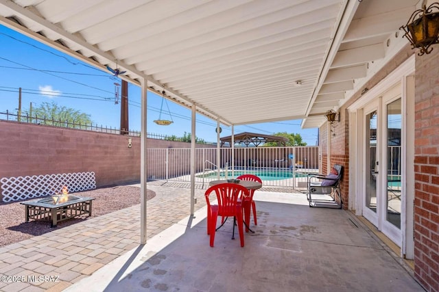 view of patio with a fenced backyard and a fire pit