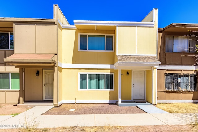 townhome / multi-family property with a shingled roof