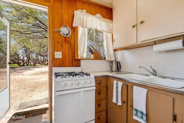 822 E Pomerene Rd, Benson, AZ 85602 - kitchen with white range with gas stovetop, a sink, light countertops, and tasteful backsplash