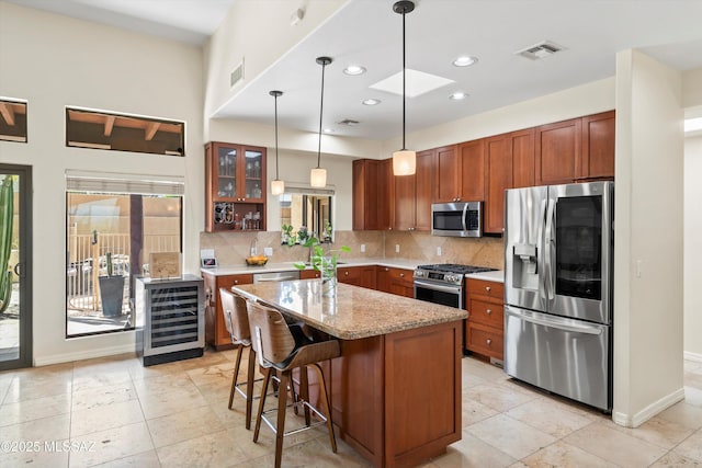 kitchen with tasteful backsplash, decorative light fixtures, visible vents, wine cooler, and appliances with stainless steel finishes