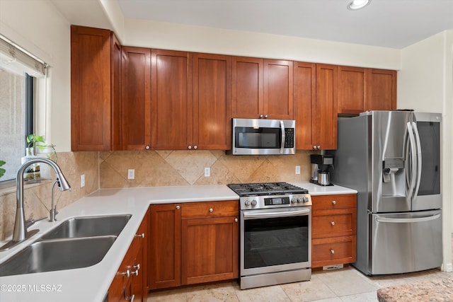 kitchen with a sink, backsplash, light countertops, and stainless steel appliances