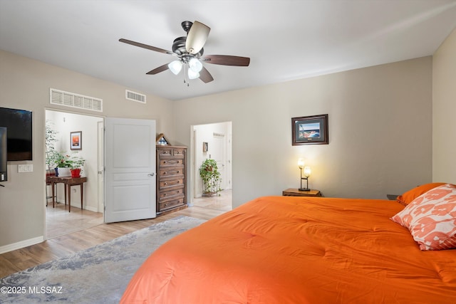 bedroom featuring wood finished floors, ceiling fan, baseboards, and visible vents