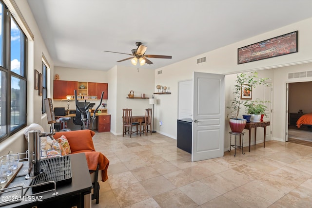 living room featuring visible vents, a ceiling fan, and a healthy amount of sunlight
