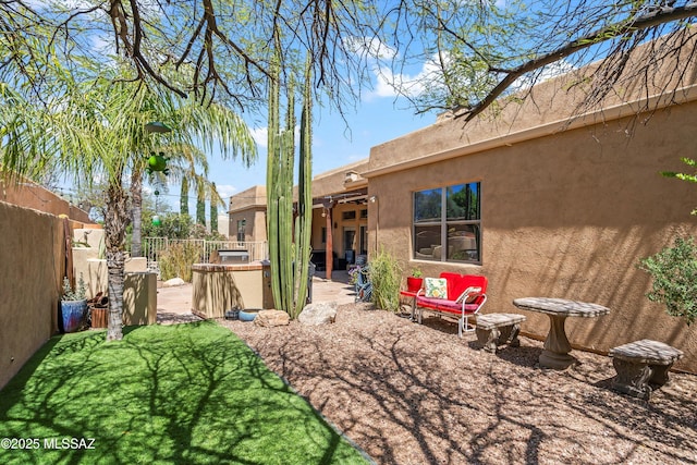 rear view of property with a fenced backyard, a patio, and stucco siding