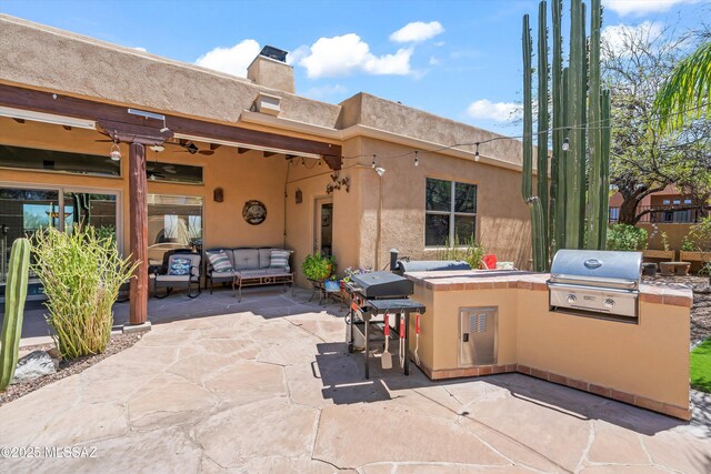 view of patio / terrace featuring a ceiling fan, an outdoor hangout area, and area for grilling