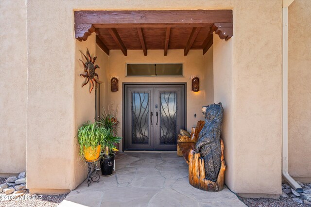 property entrance featuring french doors and stucco siding