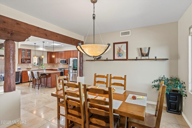 dining room featuring light tile patterned floors, visible vents, beverage cooler, and baseboards