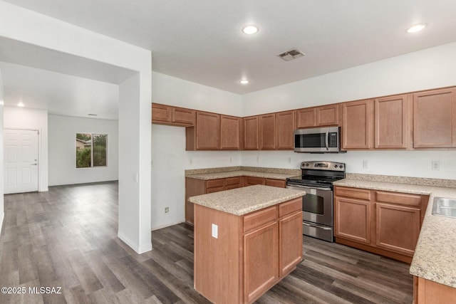 20950 E Frontier Rd, Red Rock, AZ 85145 - kitchen featuring appliances with stainless steel finishes, dark wood finished floors, a kitchen island, recessed lighting, and brown cabinetry