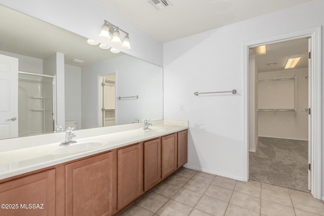 20950 E Frontier Rd, Red Rock, AZ 85145 - full bath with tile patterned floors, a stall shower, double vanity, a walk in closet, and baseboards