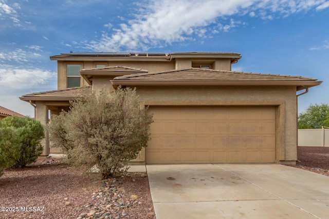 20950 E Frontier Rd, Red Rock, AZ 85145 - view of front facade featuring an attached garage, driveway, solar panels, stucco siding, and fence