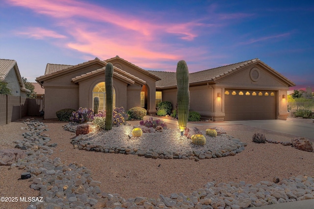 65749 E Mesa Ridge Ct, Tucson, AZ 85739 - view of front facade with a tile roof, an attached garage, fence, stucco siding, and driveway