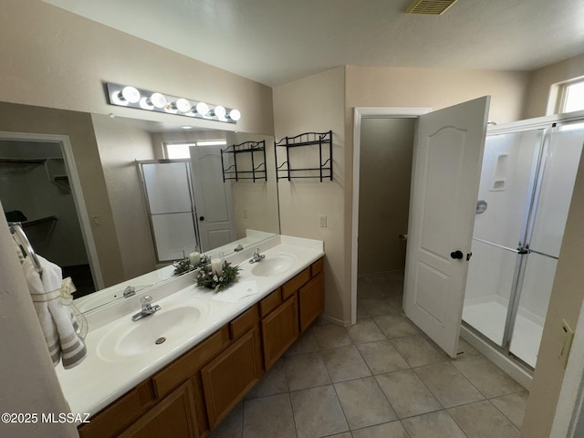 7456 E Placita Del Espiritu, Tucson, AZ 85715 - full bath featuring a stall shower, a spacious closet, double vanity, and tile patterned floors