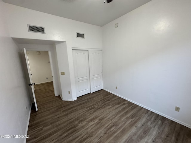 7456 E Placita Del Espiritu, Tucson, AZ 85715 - unfurnished bedroom featuring dark wood-style floors, baseboards, and a closet