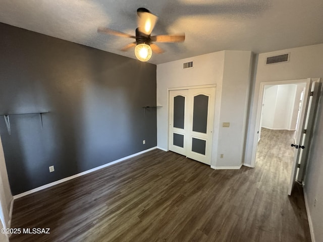 7456 E Placita Del Espiritu, Tucson, AZ 85715 - unfurnished bedroom with dark wood finished floors, baseboards, a closet, a textured ceiling, and a ceiling fan