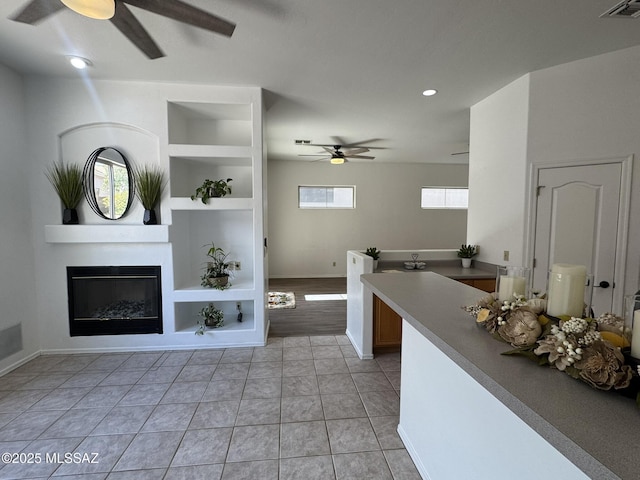 7456 E Placita Del Espiritu, Tucson, AZ 85715 - kitchen with a ceiling fan, a glass covered fireplace, light tile patterned floors, recessed lighting, and baseboards