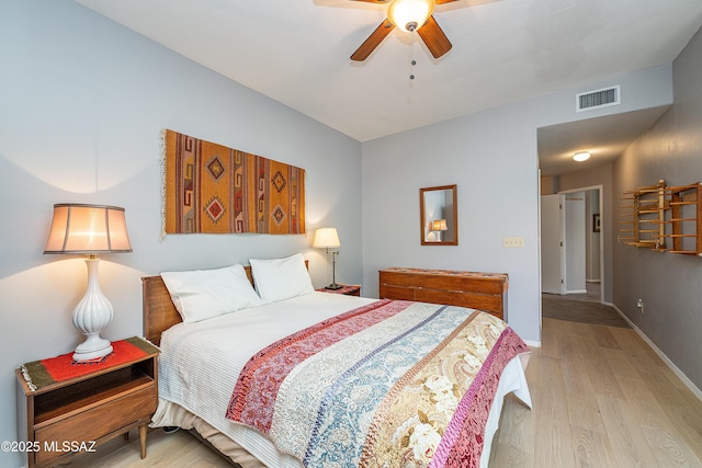 bedroom with baseboards, light wood finished floors, ceiling fan, and visible vents