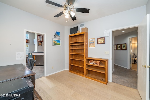 office space with visible vents, ceiling fan, light wood-type flooring, and baseboards