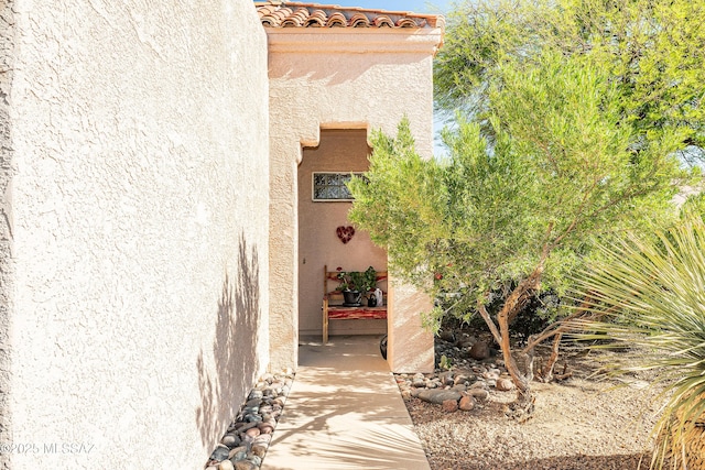 doorway to property with a tiled roof and stucco siding
