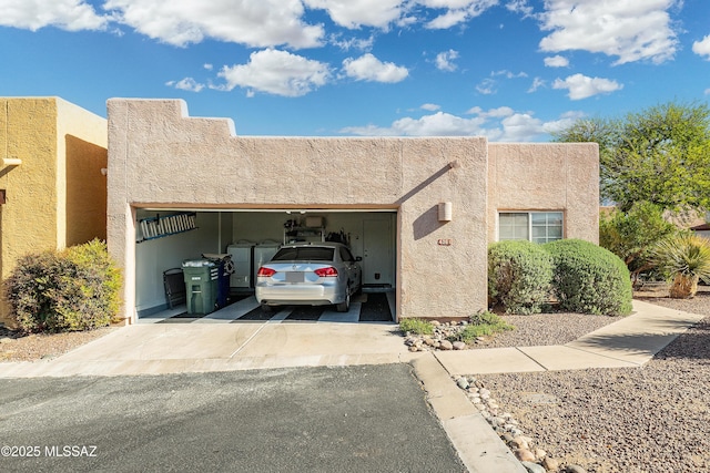 view of front of property with aphalt driveway, stucco siding, and an attached garage