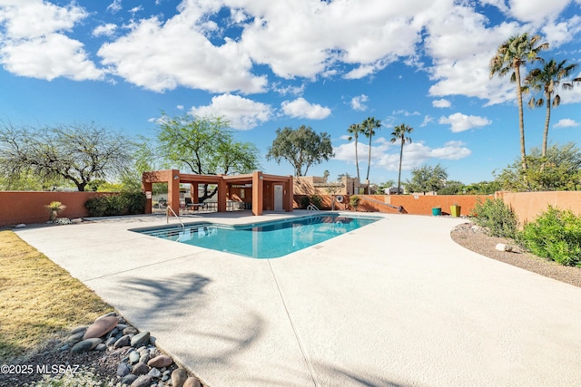 community pool featuring a fenced backyard and a patio