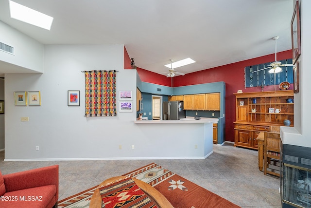 kitchen with light tile patterned floors, a skylight, stainless steel refrigerator with ice dispenser, and visible vents