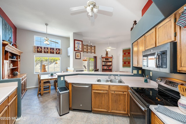 kitchen with ceiling fan, a peninsula, appliances with stainless steel finishes, light countertops, and a sink