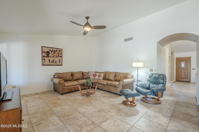 living room featuring a ceiling fan, light tile patterned floors, arched walkways, baseboards, and visible vents