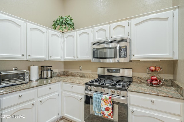 kitchen with appliances with stainless steel finishes and white cabinetry