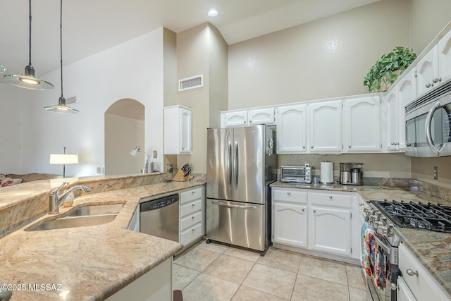 kitchen featuring white cabinets, stainless steel appliances, visible vents, a sink, and high vaulted ceiling